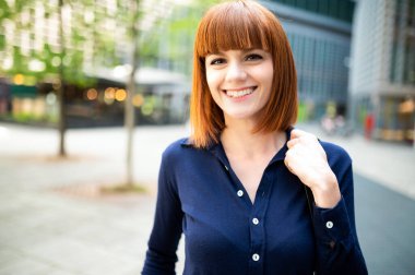 Dışarıda çantasını tutan bir kadın var.