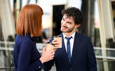 İş ortakları, kahve molası sırasında modern bir şehir ortamında birlikte tartışırlar.
