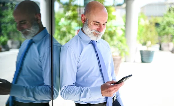 一个漂亮时髦的秃头经理在户外用智能手机 — 图库照片