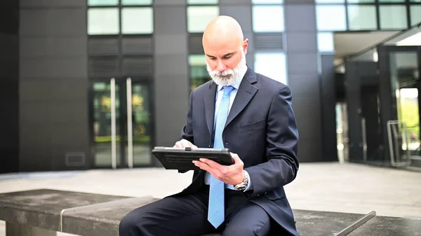 时尚经理坐在一座现代化城市的长椅上 用平板电脑 — 图库照片