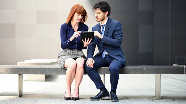 Dois Colegas Negócios Usando Tablet Livre Sentado Banco — Fotografia de Stock