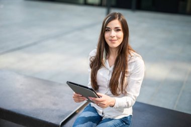 Gülümseyen iş kadını dijital tablet kullanıyor.
