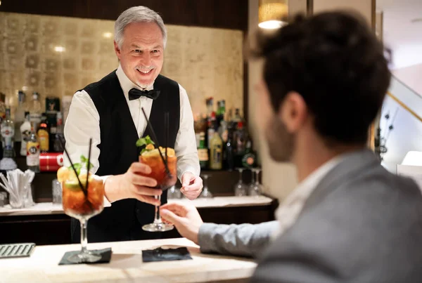 Starší Číšník Servírující Koktejly Muži Luxusním Hotelu — Stock fotografie