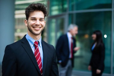 Modern bir kentsel ortamda açık havada gülümseyen iş ekibi