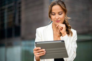 Gülümseyen iş kadını dijital tablet kullanıyor.