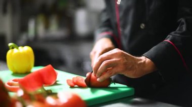 Kırmızı biber kesen bir şefin yakın çekimi.