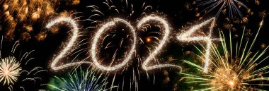 Takvim değişikliğini 2024 'e renkli bir şekilde karşılayan muhteşem kutlama havai fişekleri gösterisi. Parlak. Ve mutlu yıllar gece gökyüzünde ışık gösterisi