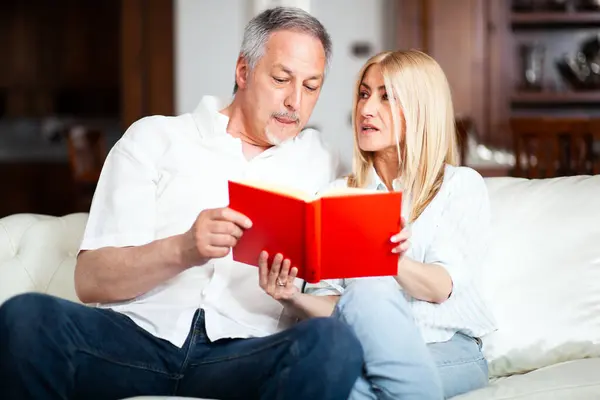 Mature couple reading a book together