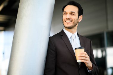 İçerik uzmanı bir ofis binasının önünde kahve molası vermeyi seviyor.