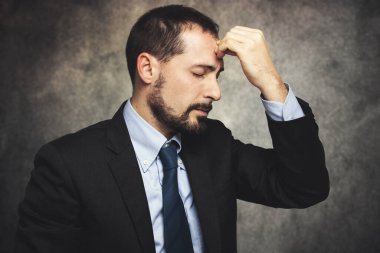 Düşünceli ve stresli bir ifadeyle genç iş adamı
