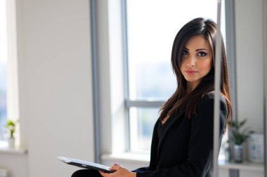 Modern ofiste tableti olan kendine güvenen iş kadını, çevrimiçi, başarıyı ve hırsı somutlaştıran.