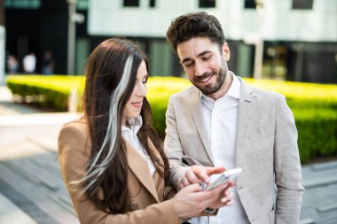 Açık havada akıllı telefon kullanan birkaç iş adamı.