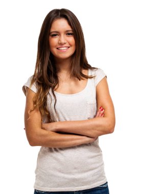Parlak bir gülüşü olan, kollarını kavuşturmuş, beyaz bir arka planı olan kendinden emin genç bir kadın. Güzellik ve güven yayar, bir anlık neşe yakalar.