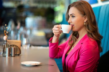 Kafede kahve içen güzel bir kadın.