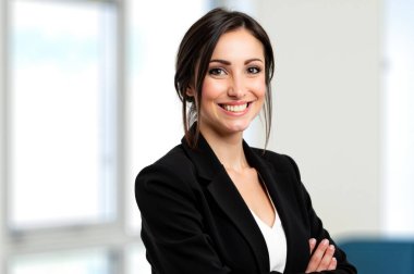 Modern ofiste gülümseyen kendine güvenen iş kadını, lider ve girişimci olarak profesyonelliği ve başarıyı yayıyor. Beyaz yakalı kadın kariyerinde mutluluk ve kararlılık yayıyor. 
