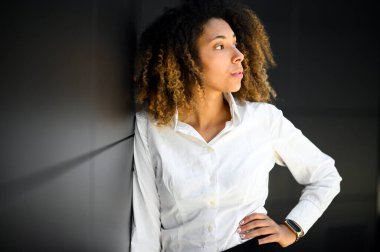 Kendine güvenen Afro-Amerikan bayan yönetici. Düşünceli bir ifadeyle.