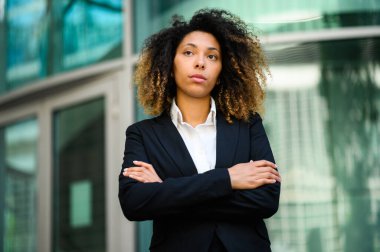 Kendine güvenen genç Afro-Amerikan bayan yönetici kollarını kavuşturdu. 