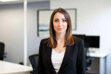 Modern ofiste duran kendine güveni tam bir iş kadını. Kurumsal ortamda profesyonelliği ve başarıyı temsil ediyor.
