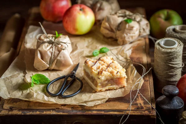 Delicious and fresh take away apple pie packed in a paper. Apple pie with fruit and crumble.