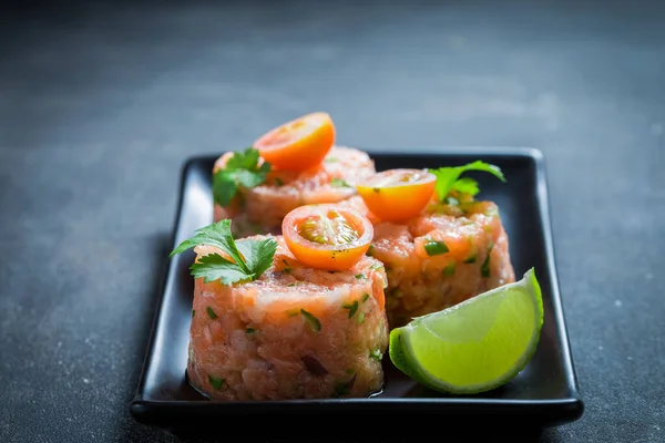 チェリートマトとライムを使った新鮮で生のサーモンのタルタル 野菜と健康的な魚のターゲット — ストック写真