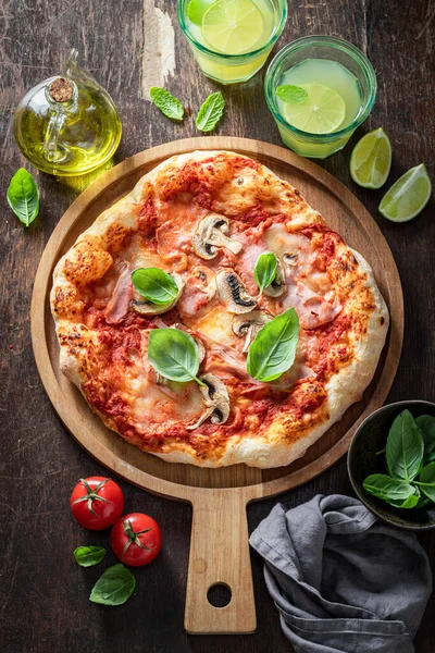 Spicy Capricciosa pizza with cheese, ham and mushrooms. Traditional Italian pizza. Capricciosa pizza with ham, cheese and mushrooms.