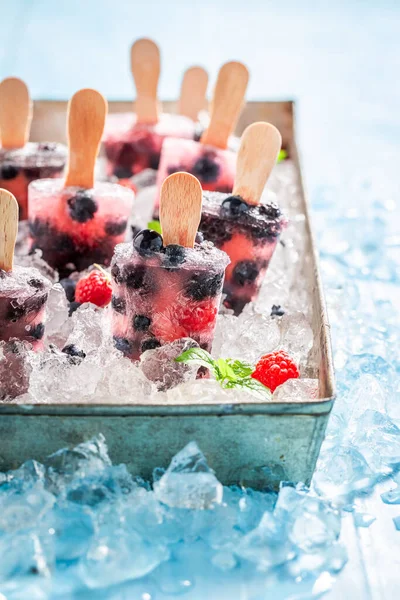 Delicious and homemade berry fruits ice cream on a stick. Frozen forest fruits as sorbet ice cream.