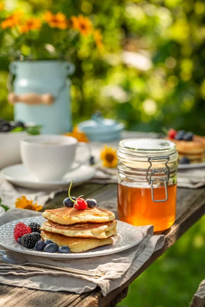 日当たりの良い庭で朝食のための新鮮で熱いアメリカのパンケーキ 春の庭での朝食 — ストック写真