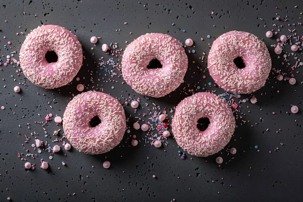 Yummy and fresh pink donuts for Fat Thursday festive. Donuts is most popular dessert.