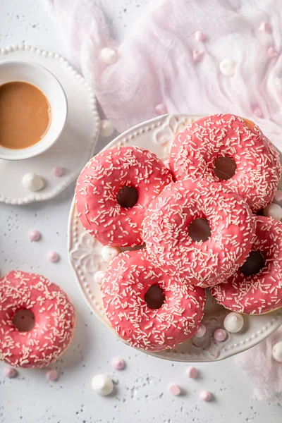 stock image Colorful and tasty pink donuts and coffee topped with sprinkles. Donuts and coffee is best dessert ever.