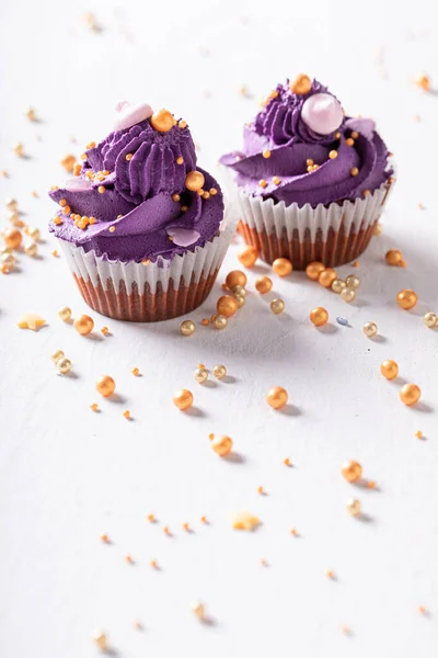 甜而好吃的杯状蛋糕 如紫色花朵形状 带有金黄色洒水的紫色甜点 — 图库照片