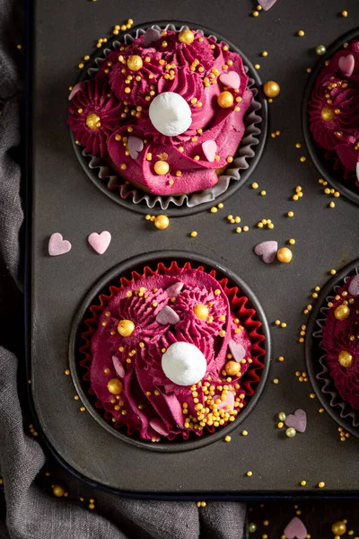 おいしいと赤いイチゴクリームと甘い赤いカップケーキ 黄金のスプリンクルと見事な赤いデザート — ストック写真