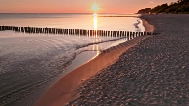 ポーランドの日の出にブレイクウォーターを介してビーチと太陽の光 — ストック動画