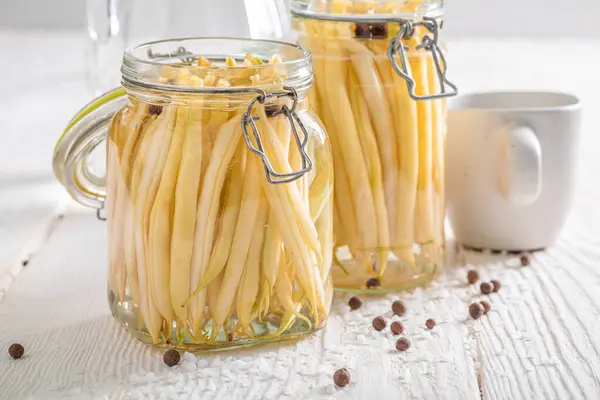 Homemade canned yellow beans in jar with herbs. Seasonal vegetables pickled for the winter.