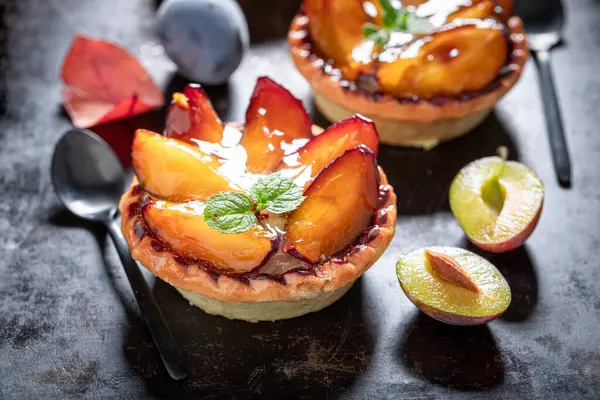 Tasty mini tart made of plums and cream. Cake with plums and cream.