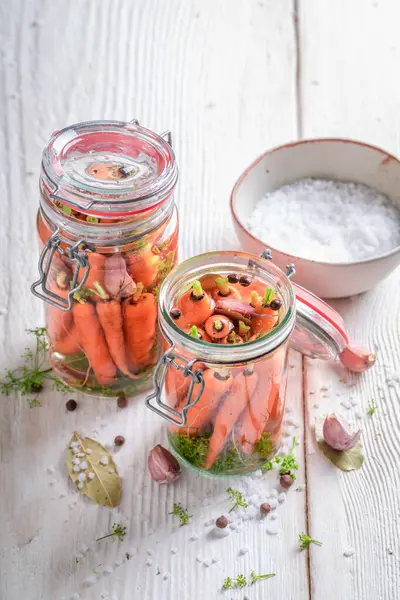 Homemade pickled carrots with garlic, dill and bay leaf.  Pickling carrots at home.