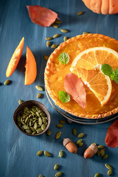 Sweet pumpkin tart made of cream and fruits. Cake with pumpkins and oranges.
