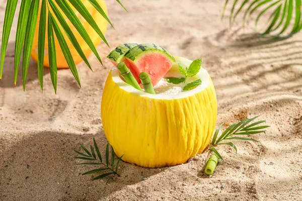 Tasty cocktail in melon on an resort island. Drink served on an exotic beach.