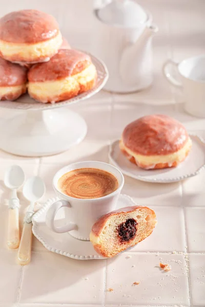 Sweet and hot doughnuts as dessert for Fat Thursday. Donuts with jam and sweet topping.