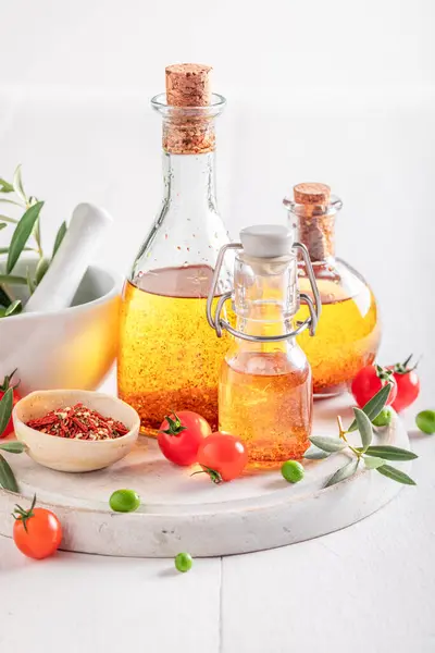Fresh and healthy oil with dried tomatoes and herbs. Flavored oil in bottle.