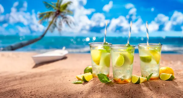 清爽的柠檬水和冰块在沙滩上的味道 在天堂海滩度假 图库图片