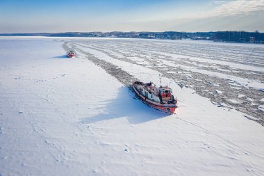 Icebreakers on Vistula river breaking the ice. Aerial view of winter in Poland, Europe clipart