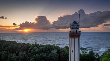 Aerial view of light beam from lighthouse at Baltic Sea with big waves in Poland. clipart