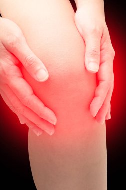 Diz kapağında kırmızı nokta, dizinde siyah nokta olan bir kadın dizine dokunuyor. Eklem ağrısı, eklem iltihabı ve tendon sorunları. Tıbbi konsept. Ortopedik sorunlar.