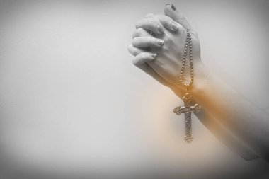 Kadın elleri gümüş bir haç tutuyor ve dua ediyordu. Tanrı kavramına güven