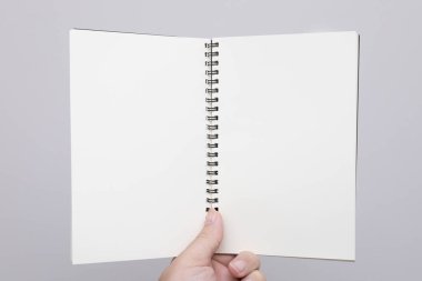 Elin boş bir defter ya da kitap tutuyor. Model kitap. Boş defter, boş kitap. Metin eklemek için kitapta boş alan.