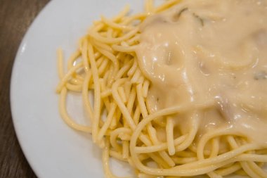 Beyaz tabakta servis edilen mantar çorbası kremalı spagetti. İtalya 'da geleneksel yiyecekler. 