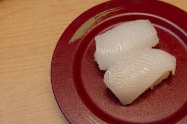 Ika Sushi ya da Japon mutfağında uzmanlaşmış taze mürekkep balığı restoranı. kırmızı tabakta servis ediliyor.. 