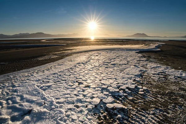 알래스카 남동부의 겨울날해 뜨면서 해변에 떠다니는 빙원들 스톡 사진