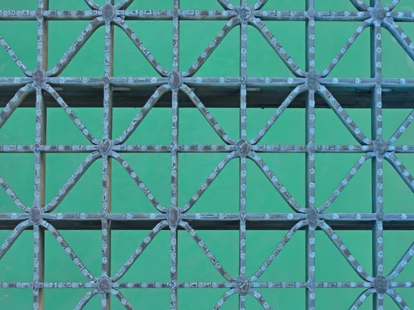 stock image Abstract patterns of a metal grate over blue water.