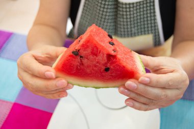 Lezzetli bir karpuzu kesiyor ve tutuyor Yemeye hazır